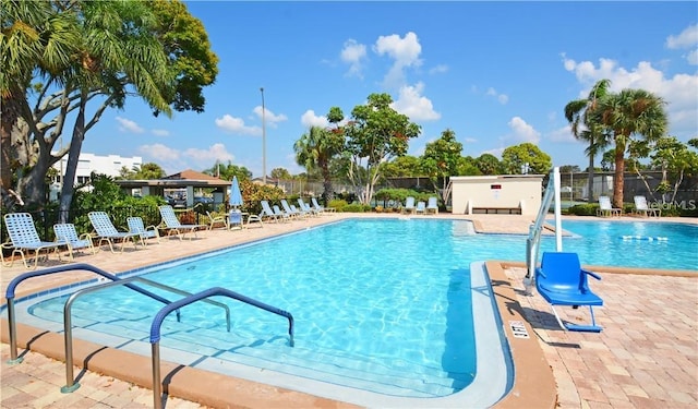 community pool with fence and a patio area