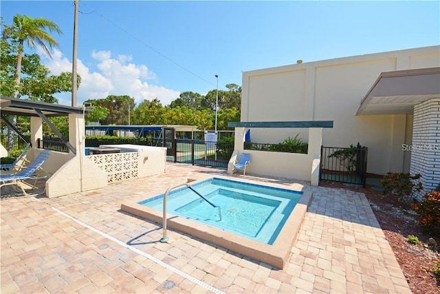 view of swimming pool with a hot tub, a patio area, and fence