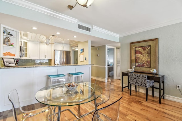 200 1st Ave Unit 309, St Pete Beach, FL 33706 - dining room with ornamental molding, light wood-style flooring, baseboards, recessed lighting, and a textured wall