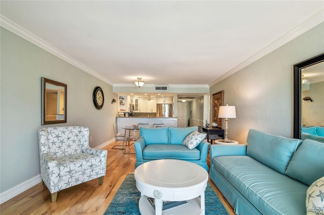 200 1st Ave Unit 309, St Pete Beach, FL 33706 - living room with ornamental molding, light wood finished floors, and baseboards