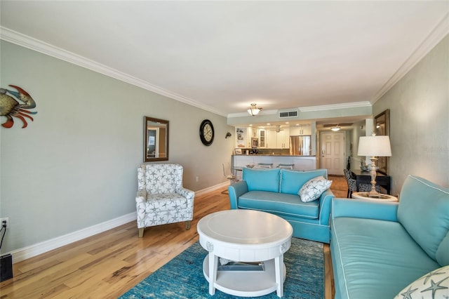 200 1st Ave Unit 309, St Pete Beach, FL 33706 - living area featuring light wood-type flooring, crown molding, and baseboards