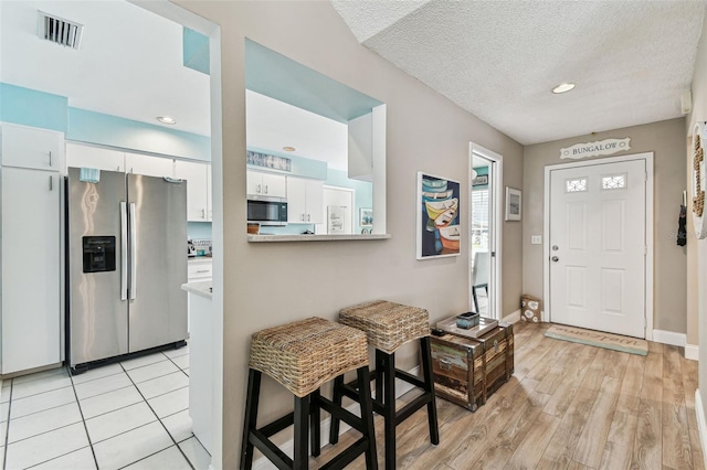 3520 51st Ave W, Bradenton, FL 34210 - foyer entrance with light wood-style flooring, baseboards, recessed lighting, and a textured ceiling