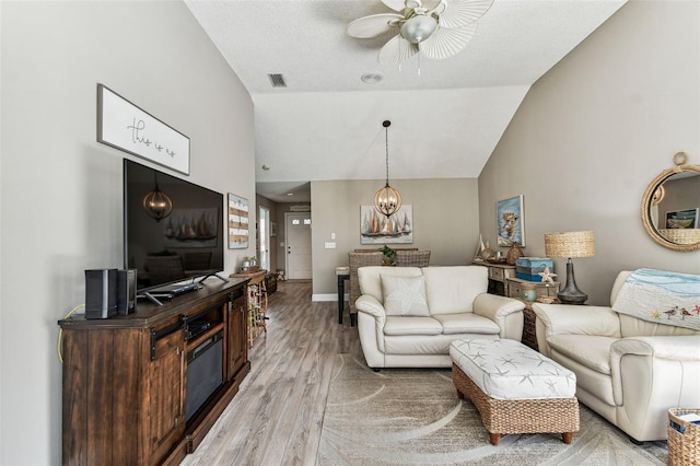 3520 51st Ave W, Bradenton, FL 34210 - living room featuring light wood-type flooring, ceiling fan, high vaulted ceiling, baseboards, and a chandelier