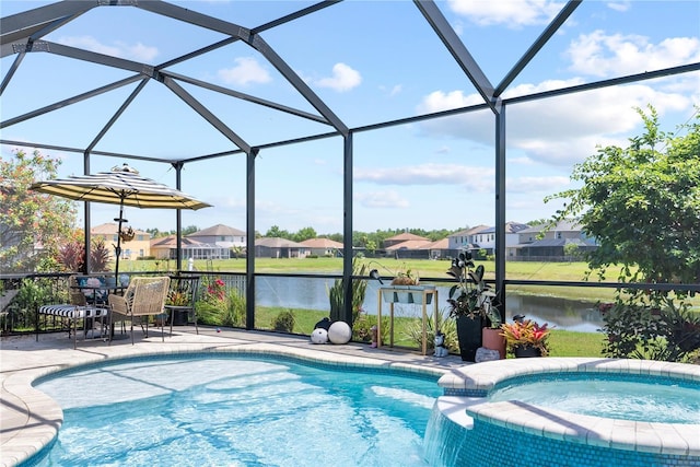 view of pool featuring a residential view, a patio area, a pool with connected hot tub, a water view, and glass enclosure