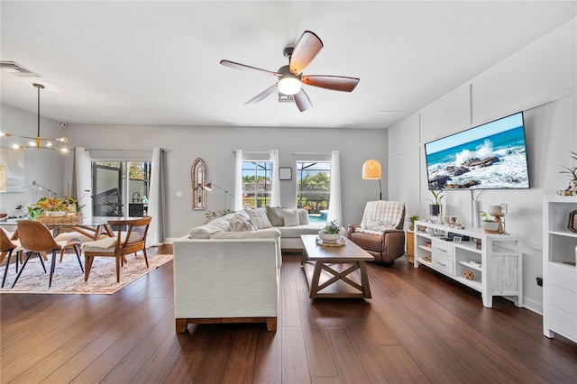 living area with ceiling fan, dark wood-style floors, and healthy amount of natural light