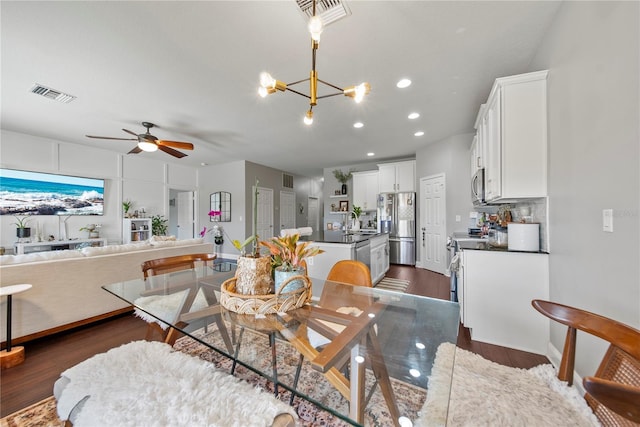 dining area featuring dark wood finished floors, a ceiling fan, recessed lighting, and a chandelier