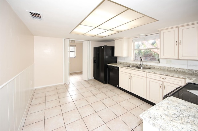 7904 Judith Cres, Port Richey, FL 34668 - kitchen featuring a sink, black appliances, white cabinetry, light tile patterned floors, and a wainscoted wall