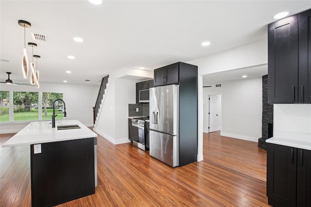 226 Willowick Ave, Temple Terrace, FL 33617 - kitchen with appliances with stainless steel finishes, a sink, dark cabinets, wood finished floors, and recessed lighting