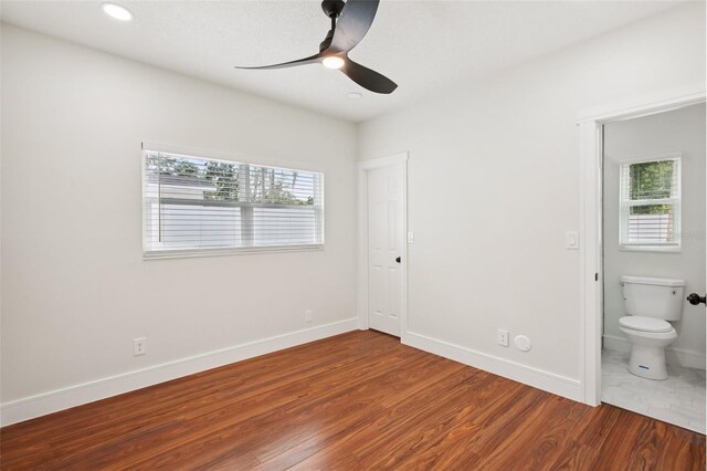 226 Willowick Ave, Temple Terrace, FL 33617 - unfurnished bedroom with multiple windows, wood finished floors, baseboards, connected bathroom, and recessed lighting