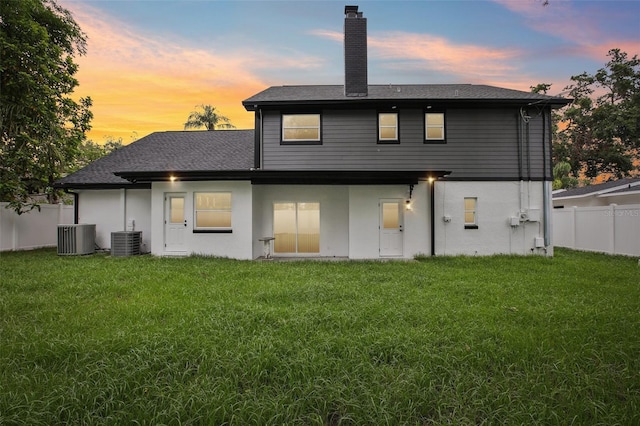 226 Willowick Ave, Temple Terrace, FL 33617 - back of house at dusk featuring cooling unit, a chimney, and roof with shingles