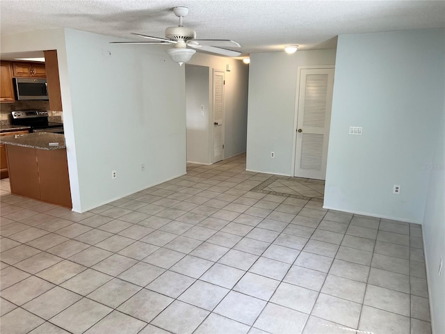 647 Fairmont Ave Unit C, Safety Harbor, FL 34695 - unfurnished living room with a ceiling fan, a textured ceiling, and light tile patterned floors
