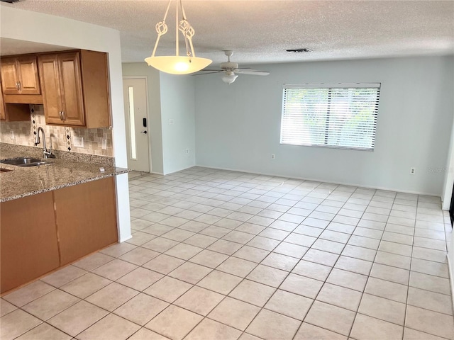 647 Fairmont Ave Unit C, Safety Harbor, FL 34695 - kitchen featuring a sink, a textured ceiling, a ceiling fan, tasteful backsplash, and decorative light fixtures