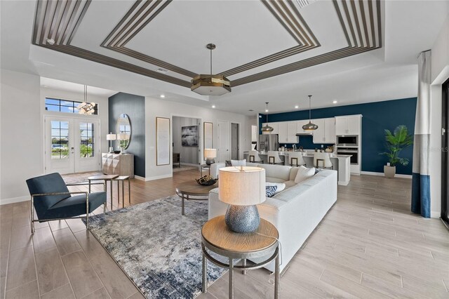 10447 New Brunswick St, Port Charlotte, FL 33981 - living area with a tray ceiling, recessed lighting, baseboards, french doors, and light wood-style floors