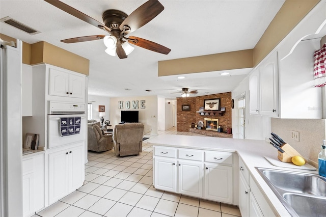 2013 Capri Rd, Valrico, FL 33594 - kitchen with a ceiling fan, a peninsula, open floor plan, white cabinetry, and light tile patterned flooring