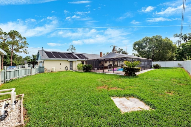 2013 Capri Rd, Valrico, FL 33594 - rear view of house with solar panels, glass enclosure, and a patio area