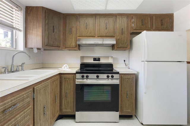 801 83rd Ave N Unit 209, Saint Petersburg, FL 33702 - kitchen with freestanding refrigerator, wall chimney range hood, electric stove, a sink, and brown cabinets