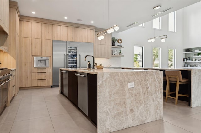 2902 S Beach Dr, Tampa, FL 33629 - kitchen featuring modern cabinets, light brown cabinetry, open shelves, light tile patterned flooring, and a kitchen island with sink