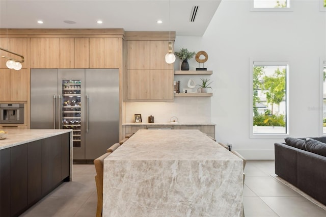 2902 S Beach Dr, Tampa, FL 33629 - kitchen with stainless steel appliances, modern cabinets, light tile patterned floors, light brown cabinets, and pendant lighting