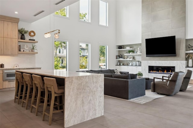 2902 S Beach Dr, Tampa, FL 33629 - kitchen featuring light brown cabinets, modern cabinets, a kitchen island, healthy amount of natural light, and a high ceiling
