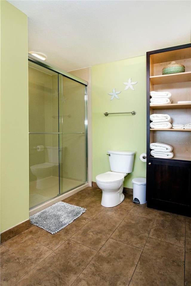 399 2nd St Unit 417, Indian Rocks Beach, FL 33785 - bathroom featuring a stall shower, toilet, and tile patterned floors