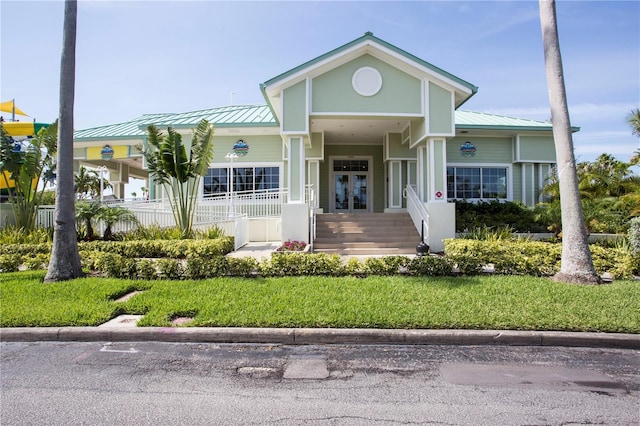 399 2nd St Unit 417, Indian Rocks Beach, FL 33785 - view of front of property with french doors, metal roof, a front lawn, and covered porch