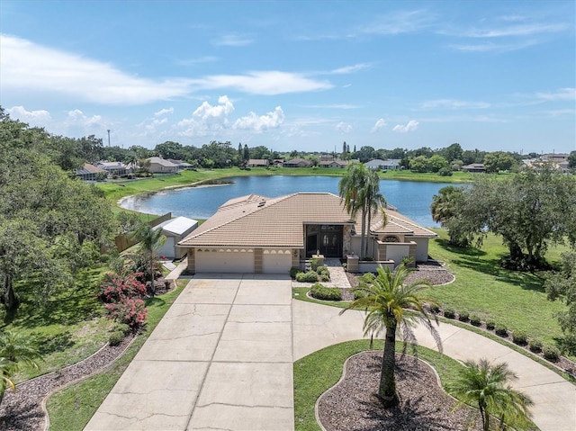 8827 Scout Lake Ct, New Port Richey, FL 34654 - view of front of property featuring curved driveway, a garage, a water view, and a tile roof