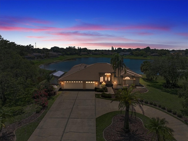 8827 Scout Lake Ct, New Port Richey, FL 34654 - view of front of home with concrete driveway, an attached garage, a water view, and a tiled roof