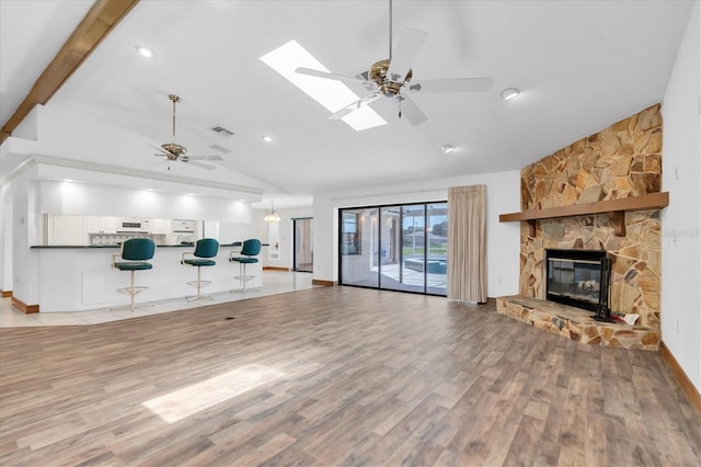 8827 Scout Lake Ct, New Port Richey, FL 34654 - unfurnished living room with lofted ceiling, ceiling fan, light wood-style flooring, a stone fireplace, and recessed lighting