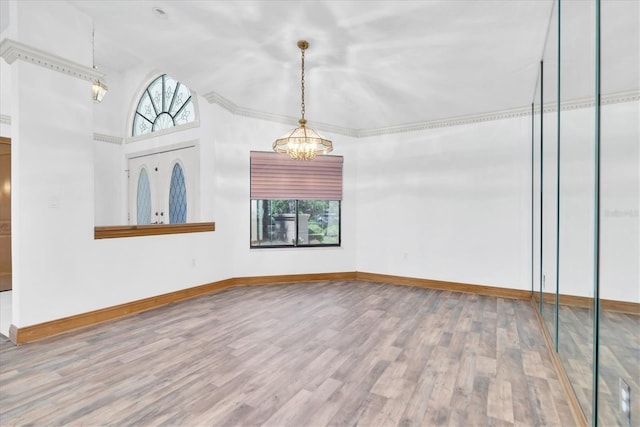 8827 Scout Lake Ct, New Port Richey, FL 34654 - empty room with a chandelier, wood finished floors, baseboards, and vaulted ceiling