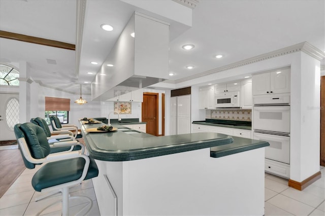 8827 Scout Lake Ct, New Port Richey, FL 34654 - kitchen featuring white appliances, dark countertops, a sink, white cabinetry, and light tile patterned flooring