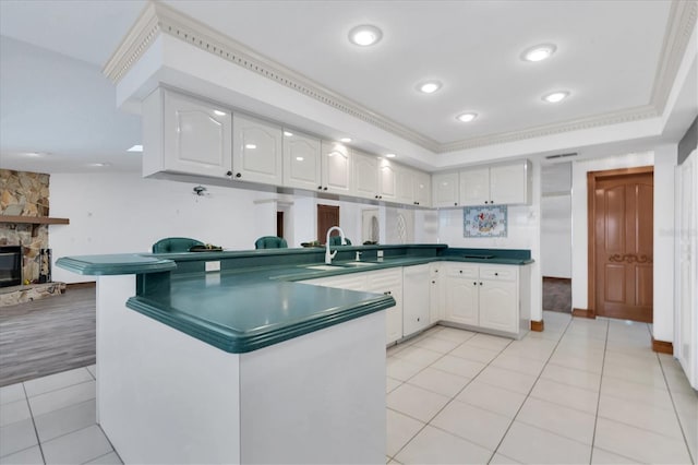 8827 Scout Lake Ct, New Port Richey, FL 34654 - kitchen with a sink, dark countertops, white cabinets, crown molding, and recessed lighting