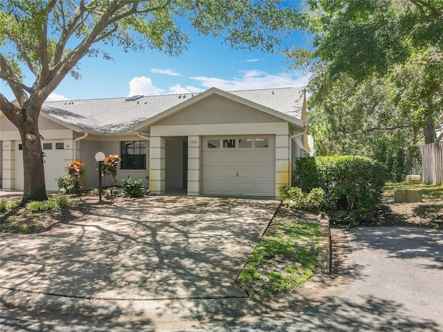 1556 Lynda Ln, Dunedin, FL 34698 - ranch-style house with a garage, driveway, stucco siding, and a shingled roof