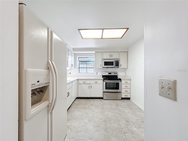 1556 Lynda Ln, Dunedin, FL 34698 - kitchen featuring appliances with stainless steel finishes, light countertops, and white cabinetry