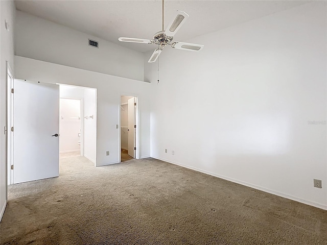 1556 Lynda Ln, Dunedin, FL 34698 - unfurnished bedroom with carpet floors, baseboards, high vaulted ceiling, ensuite bath, and a walk in closet