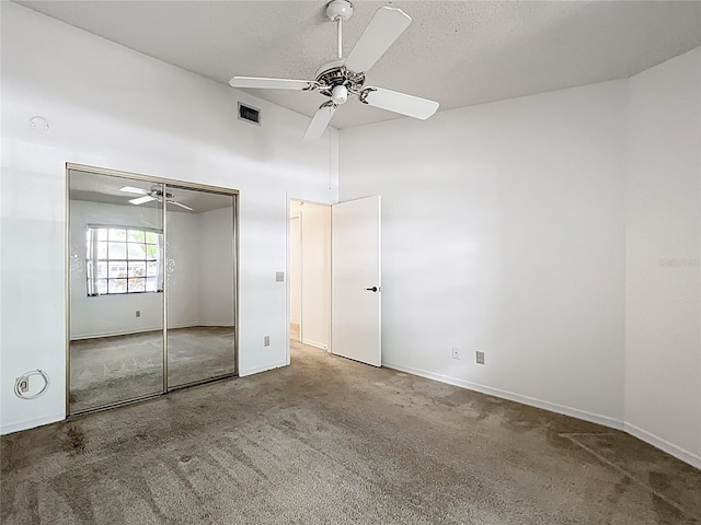 1556 Lynda Ln, Dunedin, FL 34698 - unfurnished bedroom featuring carpet flooring, a textured ceiling, a closet, a ceiling fan, and baseboards