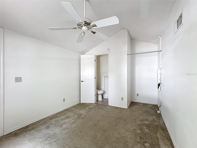 1556 Lynda Ln, Dunedin, FL 34698 - unfurnished bedroom featuring carpet floors, lofted ceiling, baseboards, ensuite bathroom, and a textured ceiling