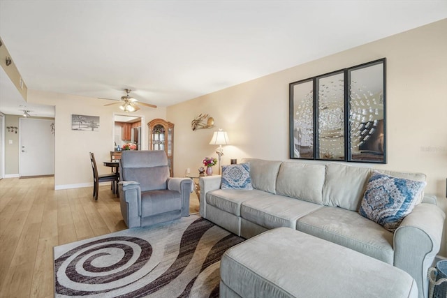 5130 Brittany Dr S Unit 604, Saint Petersburg, FL 33715 - living room with light wood finished floors, baseboards, and ceiling fan