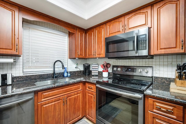 5130 Brittany Dr S Unit 604, Saint Petersburg, FL 33715 - kitchen with appliances with stainless steel finishes, a sink, tasteful backsplash, and brown cabinets