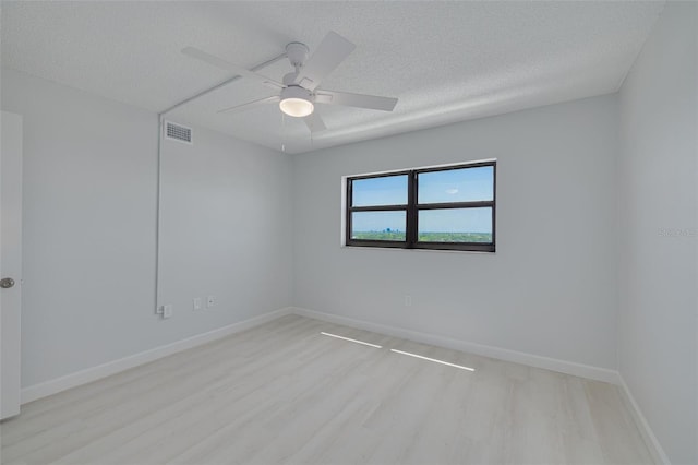7050 Sunset Dr S Unit 1401, South Pasadena, FL 33707 - unfurnished room with light wood-style floors, a textured ceiling, a ceiling fan, and baseboards