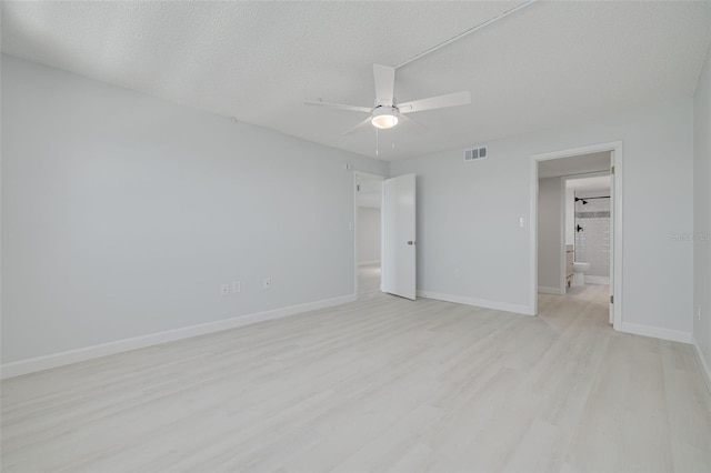 7050 Sunset Dr S Unit 1401, South Pasadena, FL 33707 - unfurnished bedroom featuring light wood-style flooring, baseboards, ensuite bath, a textured ceiling, and ceiling fan
