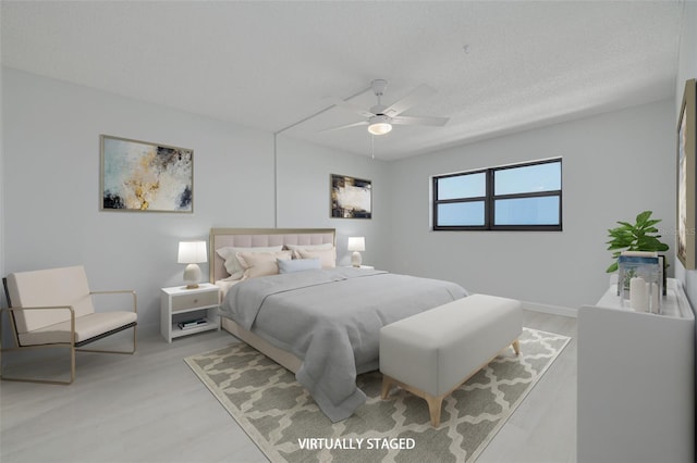 7050 Sunset Dr S Unit 1401, South Pasadena, FL 33707 - bedroom with ceiling fan, light wood-style floors, and a textured ceiling