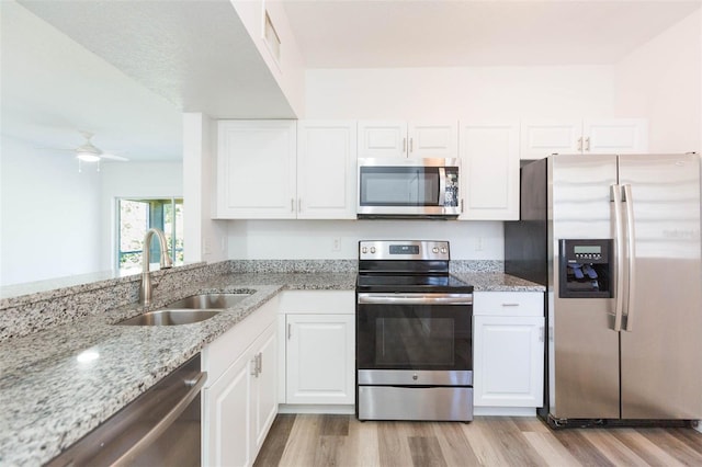 9524 Newdale Way Unit 101, Riverview, FL 33578 - kitchen featuring appliances with stainless steel finishes, a sink, light wood-style flooring, and light stone counters