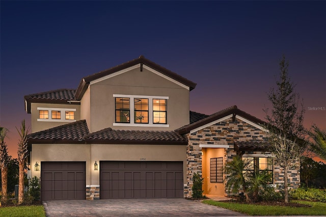 13726 Heartwood Way, Parrish, FL 34219 - view of front facade featuring stone siding, a tile roof, decorative driveway, and stucco siding