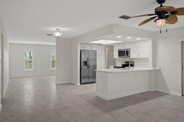 4315 Flexer Dr, Hernando Beach, FL 34607 - kitchen featuring stainless steel appliances, a peninsula, light countertops, white cabinets, and ceiling fan