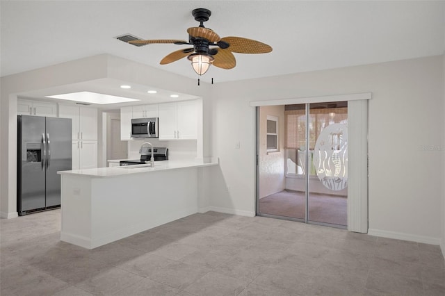 4315 Flexer Dr, Hernando Beach, FL 34607 - kitchen with appliances with stainless steel finishes, a peninsula, white cabinets, light countertops, and baseboards