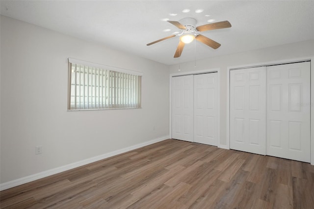 4315 Flexer Dr, Hernando Beach, FL 34607 - unfurnished bedroom featuring two closets, wood finished floors, baseboards, and ceiling fan