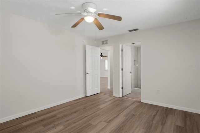 4315 Flexer Dr, Hernando Beach, FL 34607 - unfurnished bedroom featuring wood finished floors, baseboards, ceiling fan, and ensuite bathroom
