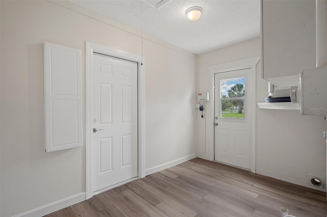 4315 Flexer Dr, Hernando Beach, FL 34607 - doorway to outside featuring light wood-type flooring, baseboards, and a textured ceiling