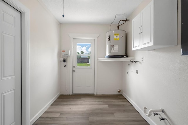 4315 Flexer Dr, Hernando Beach, FL 34607 - washroom featuring electric water heater, cabinet space, hookup for an electric dryer, light wood-style flooring, and baseboards