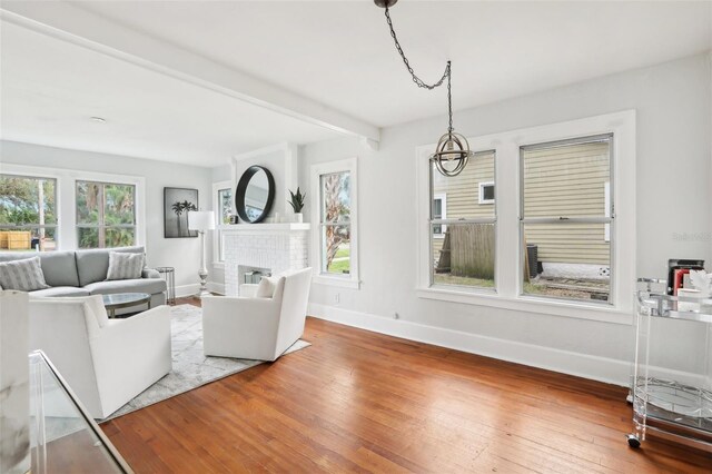 2015 3rd St S, Saint Petersburg, FL 33705 - living room featuring baseboards, hardwood / wood-style flooring, a fireplace, and a chandelier